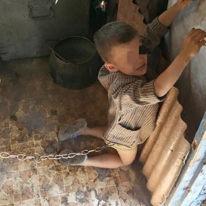 Caz CUTREMURĂTOR. Copil de 6 ani, legat cu LANȚUL în grajd și BICIUIT de tatăl său