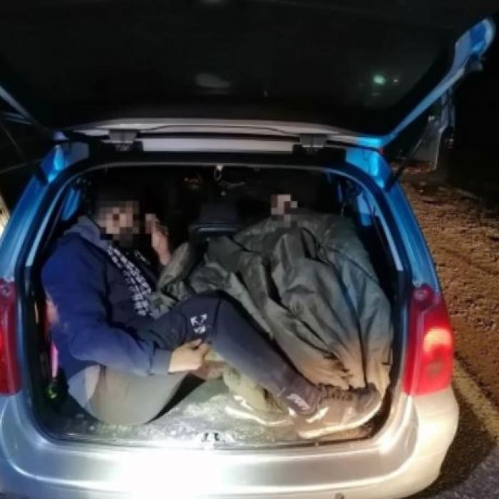 Ungaria. Șofer român, încătușat de polițiști, după ce a fost prins cu migranți, ascunși în portbagaj