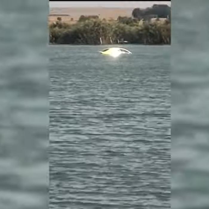 Un român a rămas mut... și fără mașină: autoturismul plutea în mijlocul unui lac. „Ia uite, fată! Plouă și cu mașini“ / VIDEO