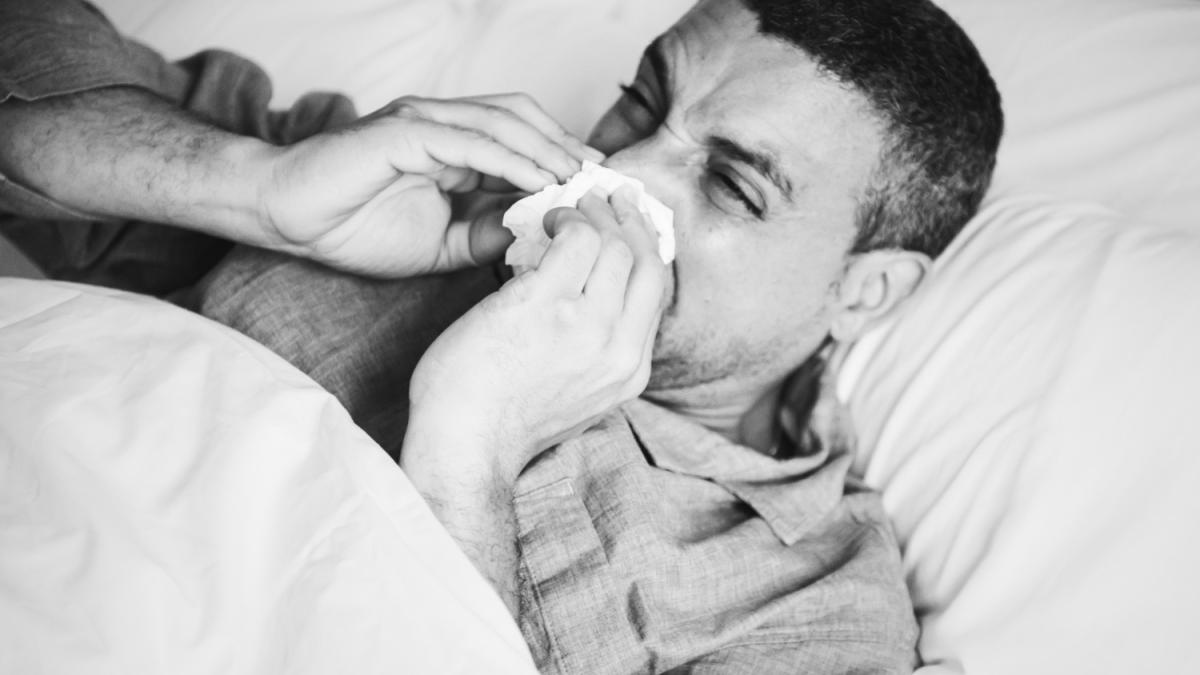 sick-man-sneezing-bed