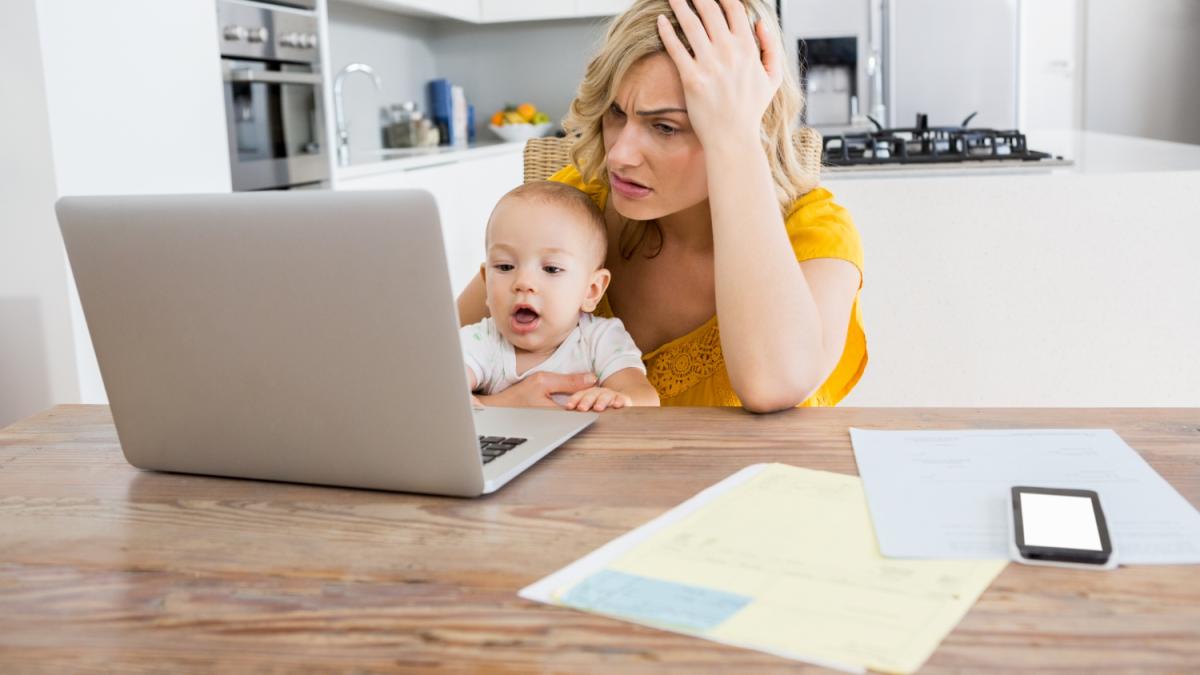 tensed-mother-using-laptop-with-her-baby-boy-kitchen_28145700