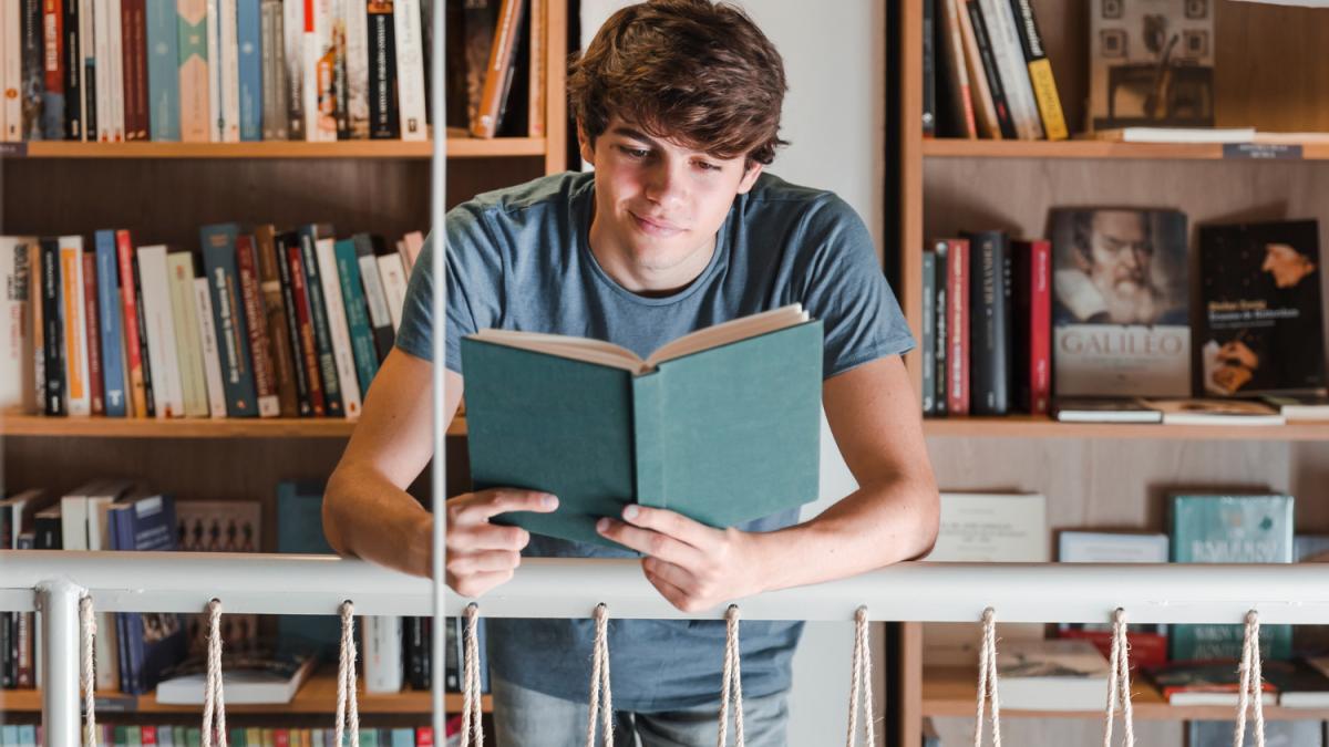 teenager-reading-book-library_49350800