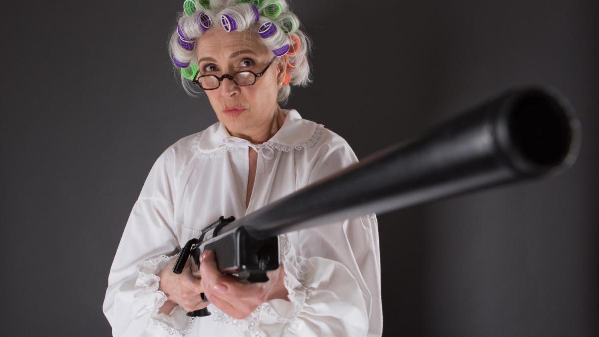 beautiful-grandmother-posing-with-weapon-studio-serious-lady-with-rollers-looking-camera-holding-rifle_61551600