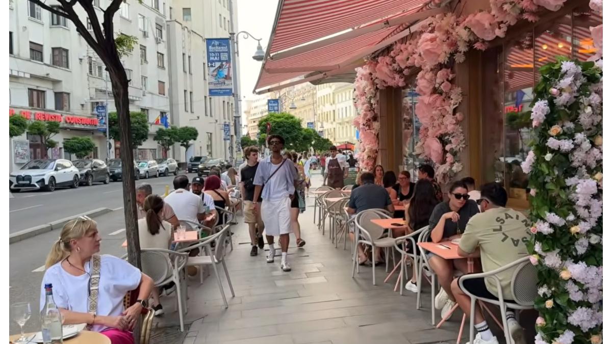 oameni la terasa restaurant pe strada