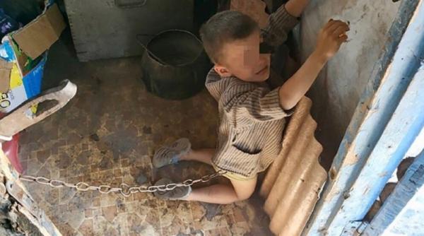 Caz CUTREMURĂTOR. Copil de 6 ani, legat cu LANȚUL în grajd și BICIUIT de tatăl său