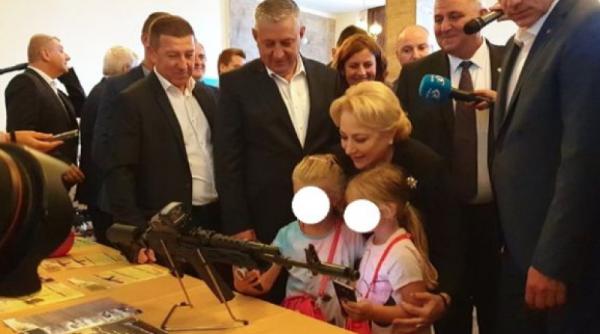 Halucinant. Dăncilă s-a fotografiat la Cugir cu două fetiţe în timp ce le arata o armă de asalt