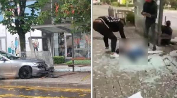 Doi români, soț și soție, spulberați de un BMW, scăpat de sub control. Mașina a intrat într-o stație de autobuz