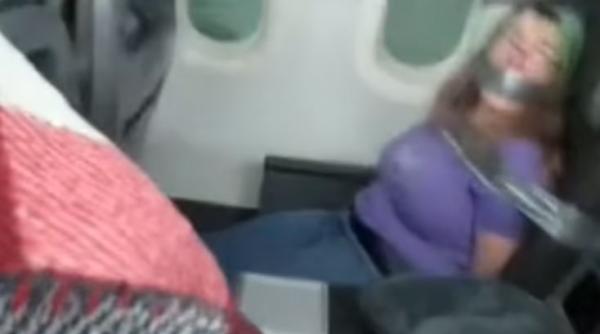 Scene șocante într-un avion. O femeie, legată cu bandă adezivă de scaun, după ce a atacat însoțitoarele de zbor