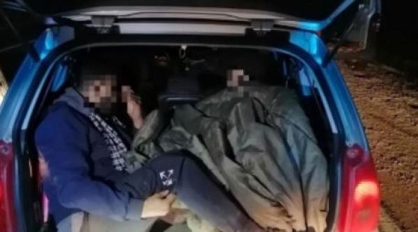 Ungaria. Șofer român, încătușat de polițiști, după ce a fost prins cu migranți, ascunși în portbagaj