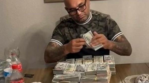 Români prinși de FBI după ce s-au lăudat pe internet cu o masă plină de bani: ”Clipul ăsta e pentru cei ce se cred șmecheri”