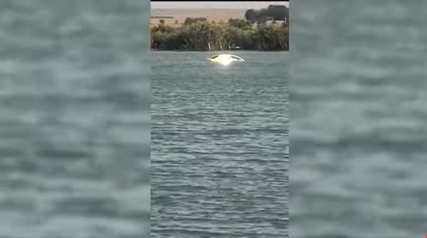Un român a rămas mut... și fără mașină: autoturismul plutea în mijlocul unui lac. „Ia uite, fată! Plouă și cu mașini“ / VIDEO