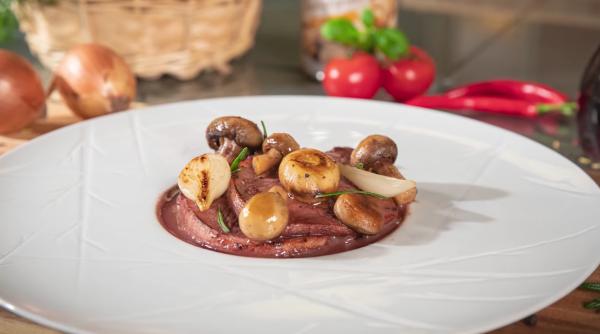 Friptură de mistreț cu sos de vin roșu și ciuperci: O rețetă savuroasă pentru gurmanzi